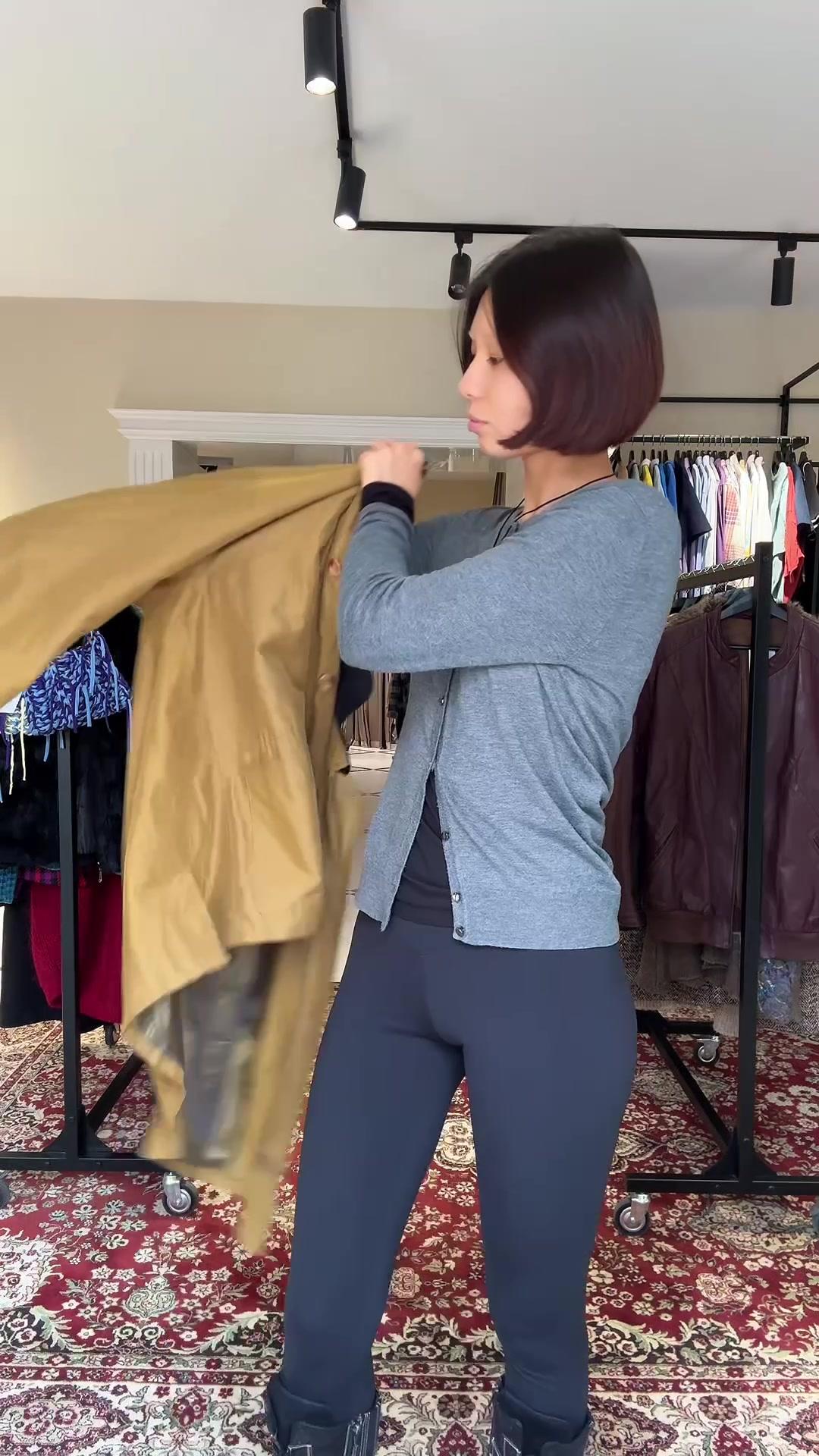 Woman Trying On Different Outerwear Jackets