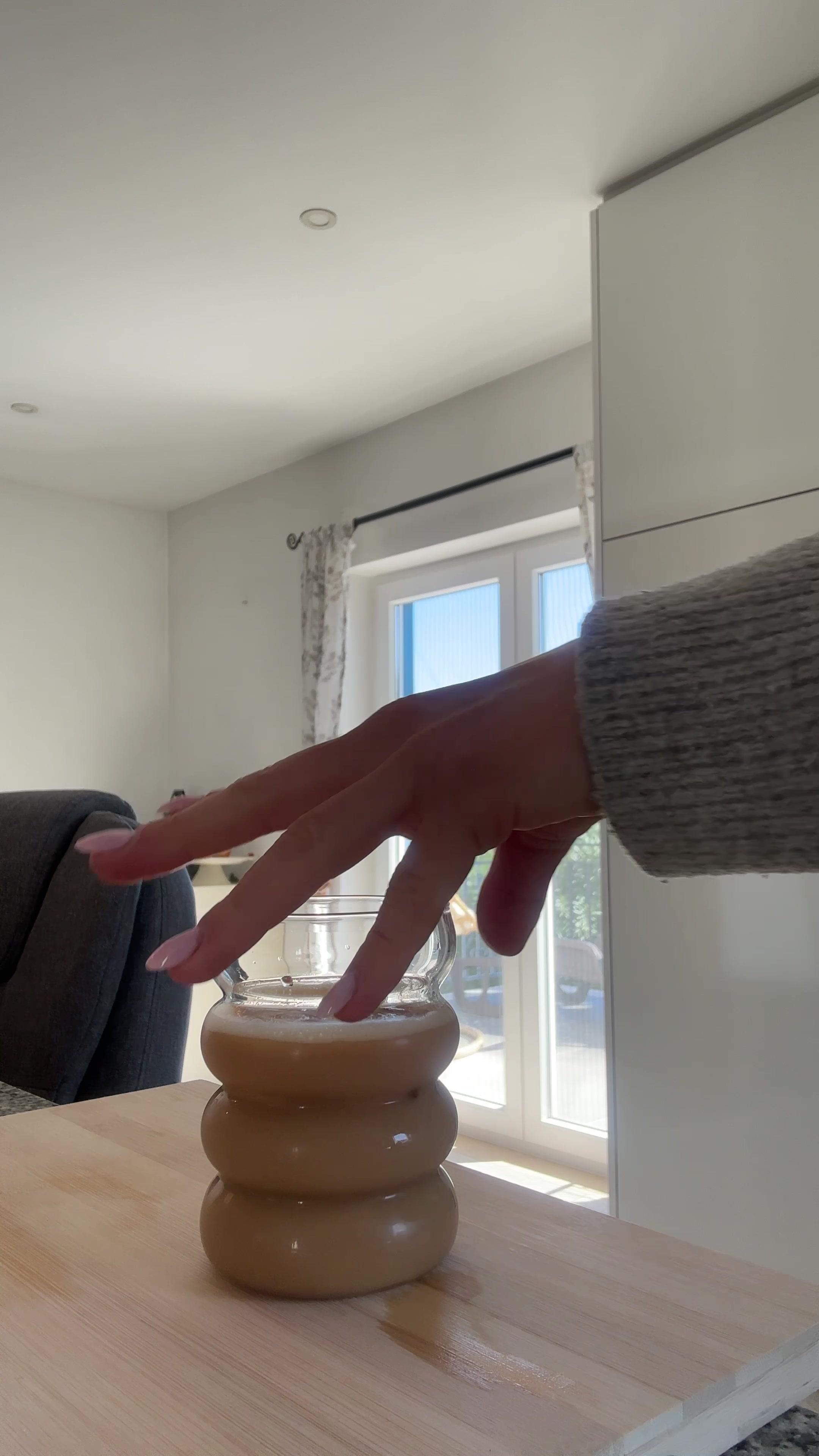 Woman Placing Coffee Glass on Counter