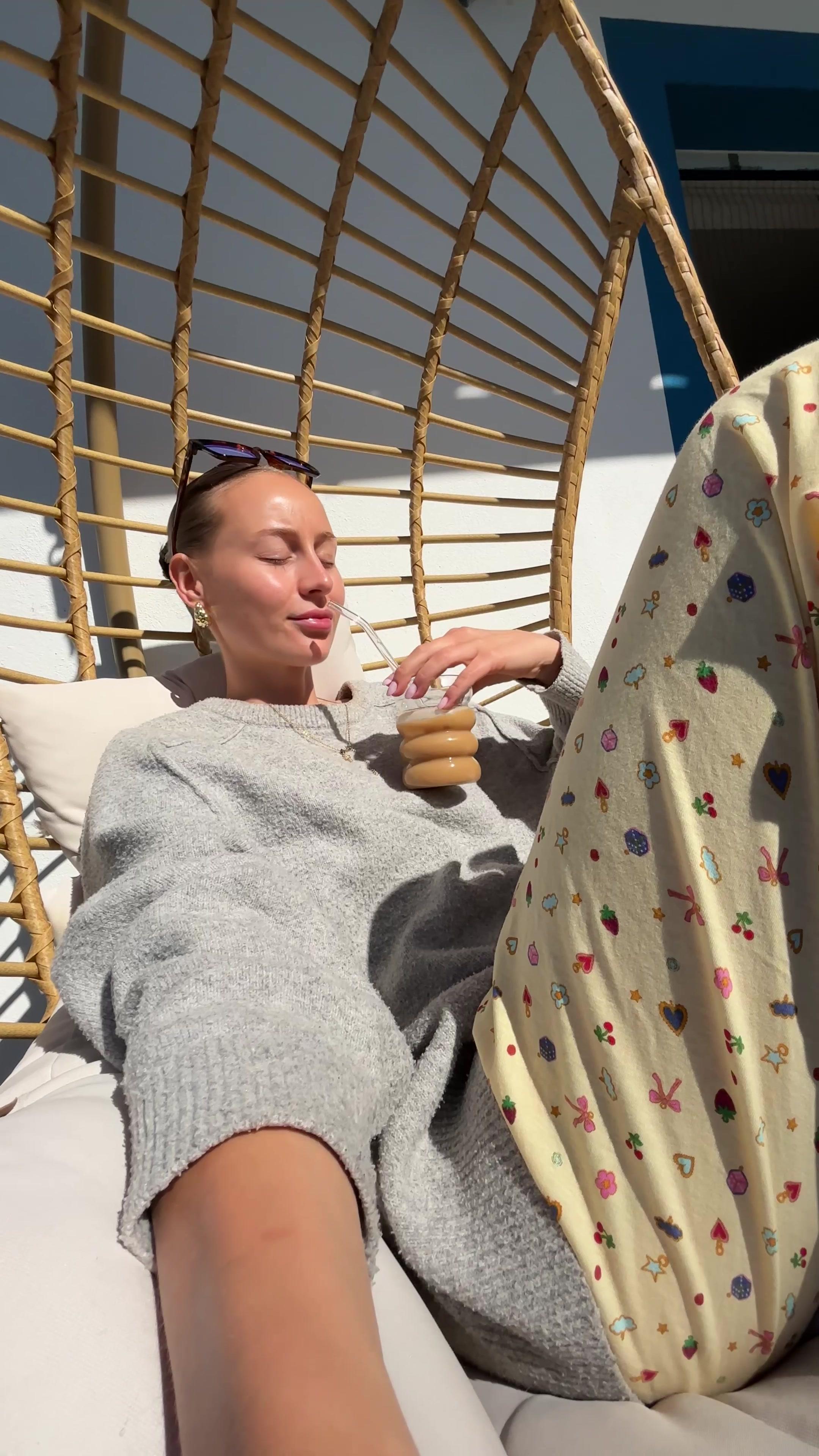 Woman Sipping Iced Coffee on Balcony