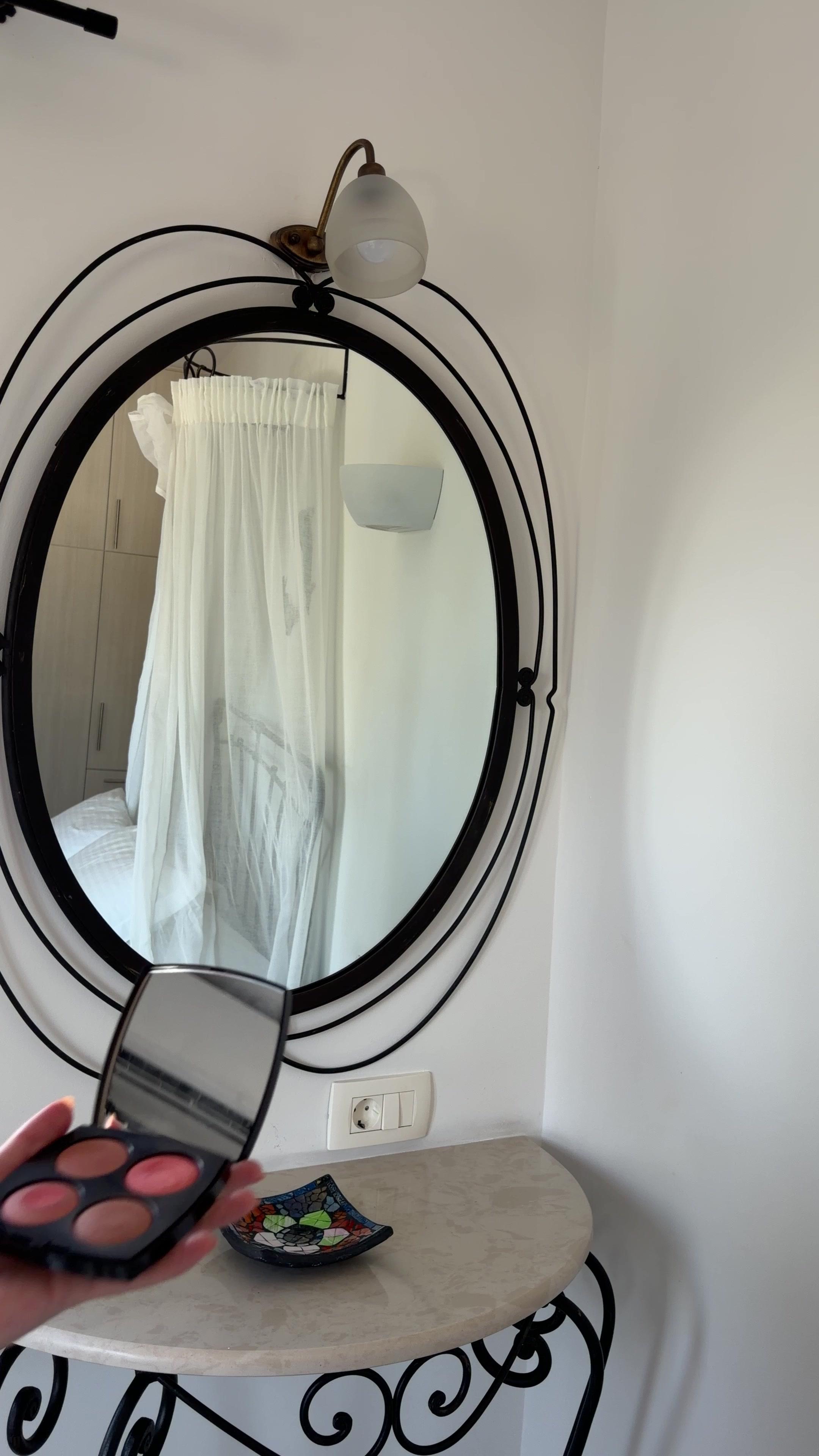 Woman Applying Makeup in Front of Mirror