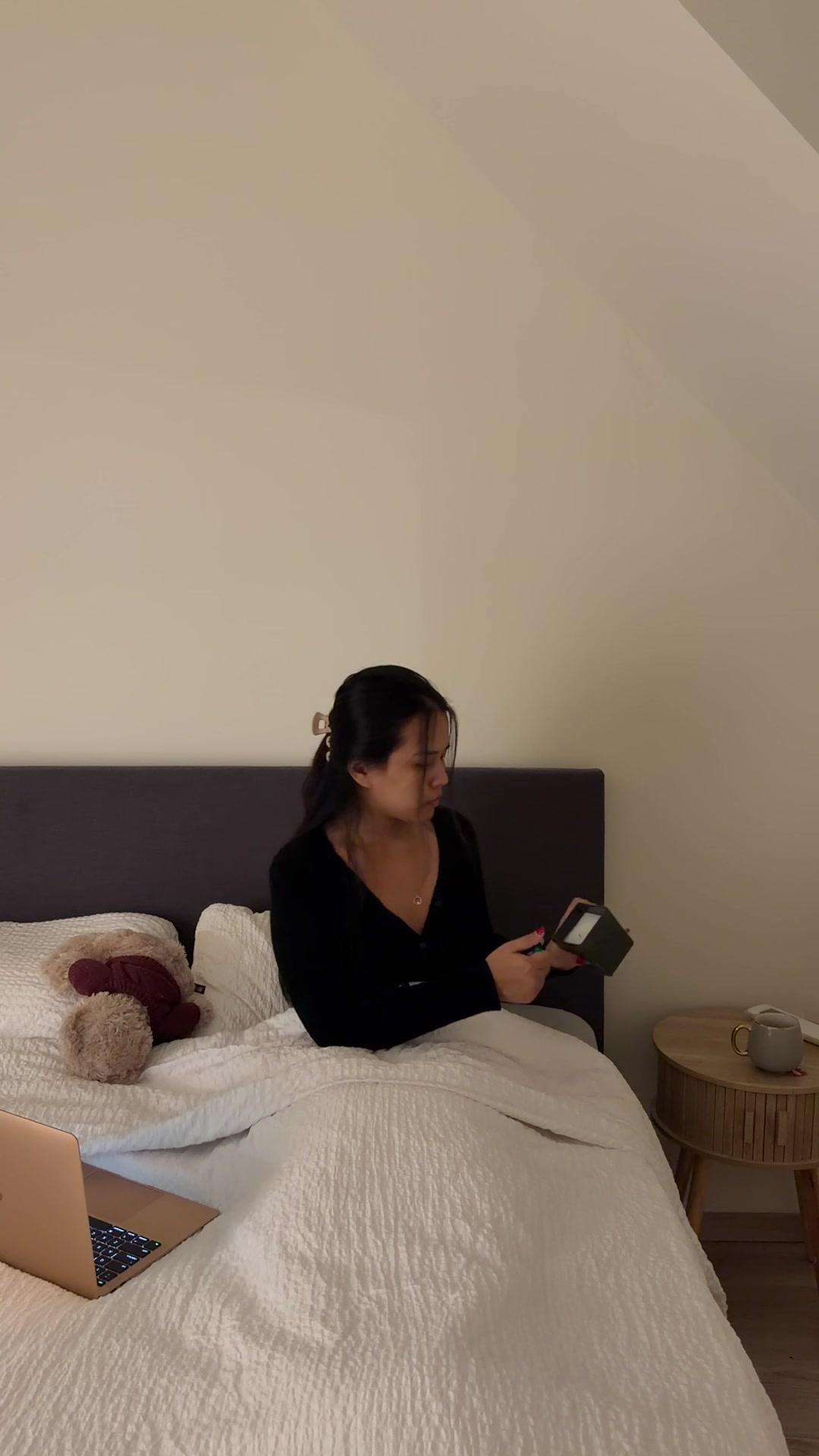 Woman Lighting Candle in Cozy Bed