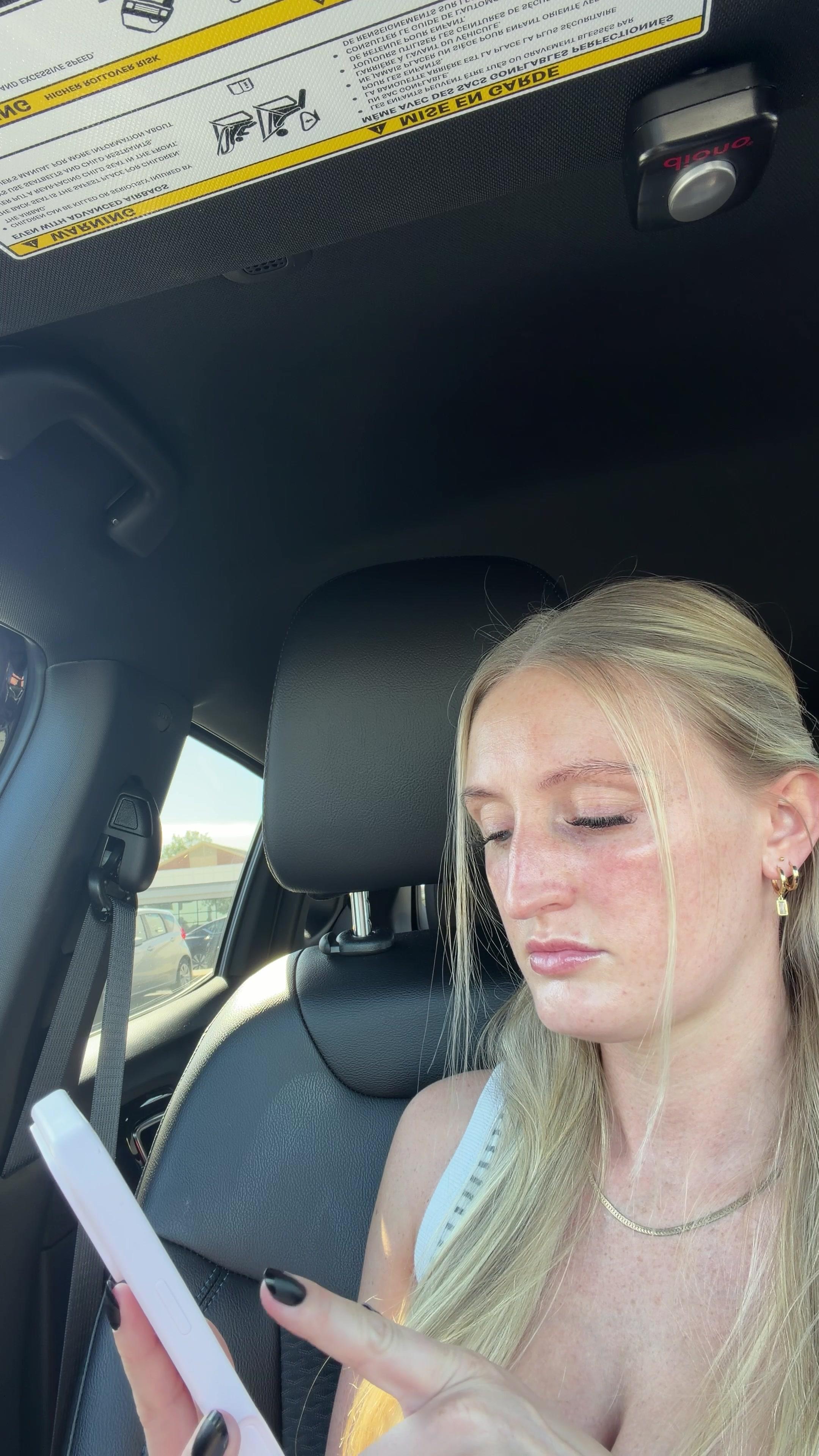 Woman Gasps Looking at Phone in Car