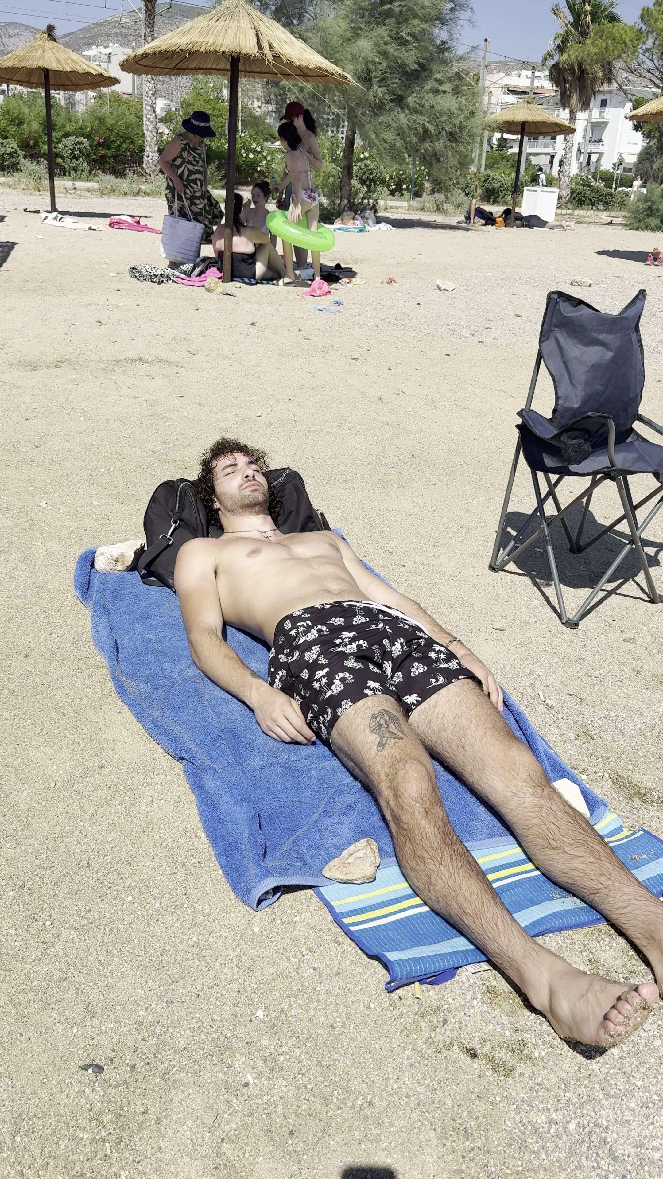 Man sunbathing on beach, called
