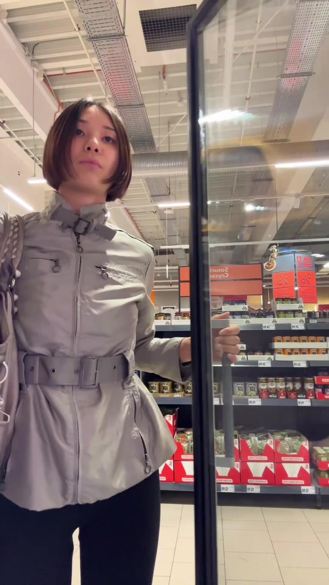 Woman Choosing Treats From Store Freezer